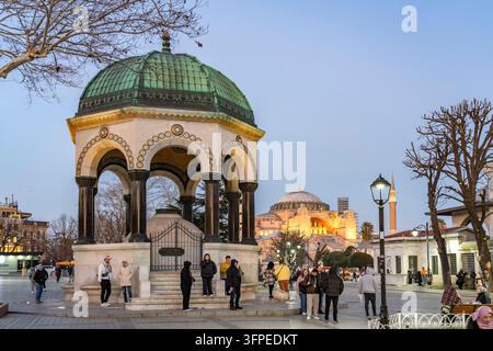 Touristen am Deutschen Brunnen (oder Kaiser-Wilhelm-Brunnen) und der Hagia Sophia in der Dämmerung, Istanbul, Türkei Stockfoto
