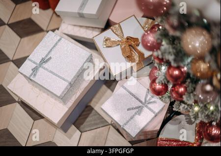 Weihnachtsgeschenke unter geschmücktem Baum mit eleganter festlicher Verpackung Stockfoto