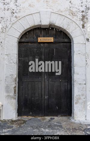 Bogenförmige Holztür mit der Aufschrift "Tür der Rückkehr" am Eingang einer historischen Festung, Zentralregion, Cape Coast, Ghana Stockfoto