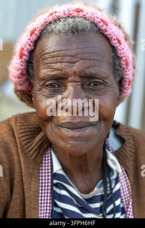 Nahaufnahme-Porträt einer älteren Frau mit einem pinken Strickhut im Kibera-Gebiet, Nairobi County, Nairobi, Kenia Stockfoto
