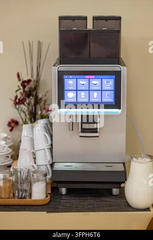 Kaffeemaschine bietet verschiedene Getränke mit einem Touchscreen-Display und Milchspender an Stockfoto