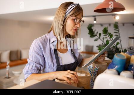Eine Frau führt im Café eine Inventur mit einer Checkliste durch. Stockfoto
