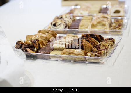 Verschiedene Süßgebäck, Kuchen und Backwaren auf Tabletts an einem Dessertbuffet Stockfoto