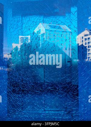 Eine Nahaufnahme einer zersplitterten blauen Glasfläche mit einem dichten Netz feiner Risse und Brüche, die Themen der Zerbrechlichkeit, Angst und eines Stockfoto