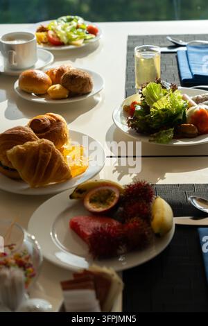 Ein farbenfrohes Frühstücksbufet mit frischen Früchten, Croissants, Salaten und erfrischenden Getränken, perfekt für einen entspannten Morgen Stockfoto