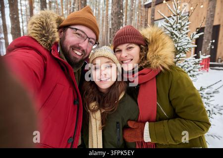 Porträt einer glücklichen Familie, die während des Winterurlaubs ein Selfie macht Stockfoto