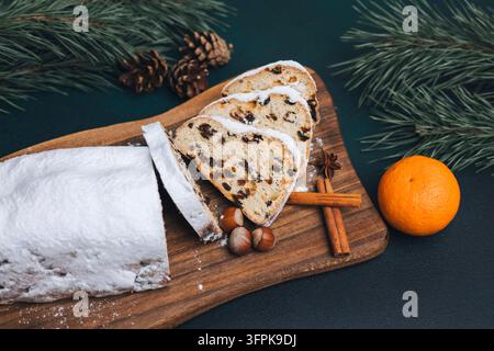 Traditionelle Weihnachtsstollen-Scheiben mit Zimt, Orange und Tannenzweigen Stockfoto