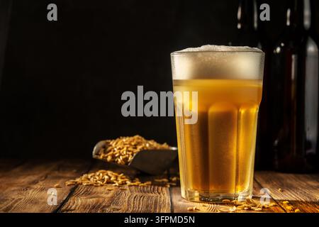 Ein Glas hausgemachtes Bier auf einem Holztisch. Glas Craft Beer auf dunklem Hintergrund. Stockfoto