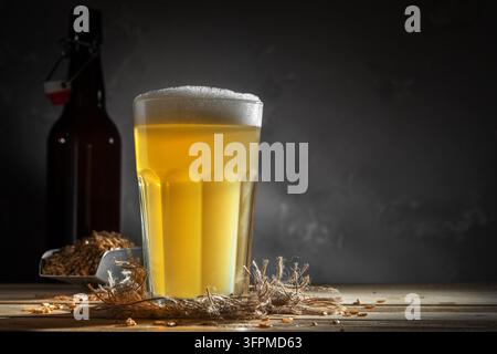 Ein Glas hausgemachtes Bier auf einem Holztisch. Glas Craft Beer auf dunklem Hintergrund. Stockfoto