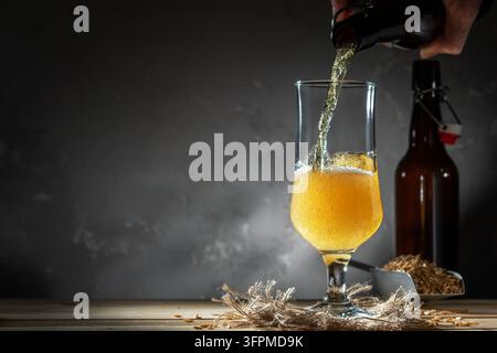 Ein Glas hausgemachtes Bier auf einem Holztisch. Glas Craft Beer auf dunklem Hintergrund. Stockfoto