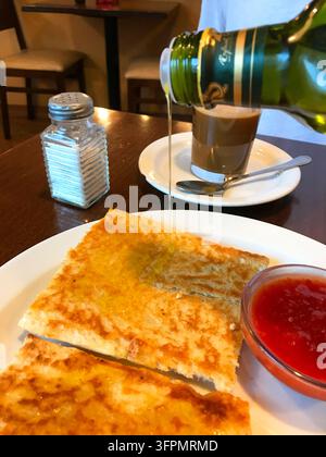 Ölflasche, die Olivenöl auf Toast gießt. Spanien. Stockfoto