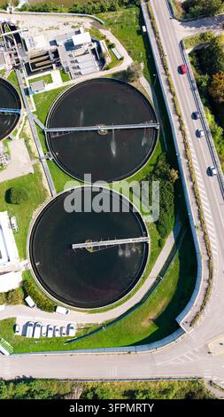 Luftbild des Depuratore di Truccazzano, einer Kläranlage mit großen kreisförmigen Sedimentationstanks, Grünflächen und Straßeninfrastruktur Stockfoto