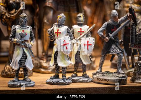 Toledo, Spanien. Nahaufnahme von detaillierten Miniatur-Templer-Ritter-Figuren mit Schwertern, Schilden und Kreuzpanzerungen, die als Souvenirs auf einem Holzregal verkauft werden Stockfoto