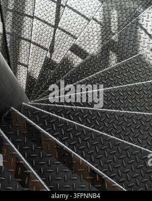 Industrielle Metall-Spiraltreppe im Treppenhaus betont geometrisches Muster und Textur, kühle Töne und kräftige Schattenlinien. Stockfoto