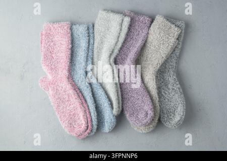 Satz flauschiger Pastellsocken aus Kaschmir- und Nerz-Mischung, angeordnet auf einem hellen Hintergrund, symbolisiert Wärme, Fürsorge und gemütlichen Komfort. Stockfoto