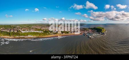 Luftaufnahme von Scarborough mit der historischen Burglandspitze, dem Hafen, dem Sandstrand und der Küstenstadt unter einem blauen Himmel in Scarborough, Engla Stockfoto