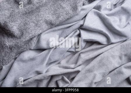 Verschiedene graue Strickstoffe, weiche und warme Kaschmir- oder Wolltexturen von Strickwaren oder gemütlichen Heimtextilien für Herbst und Winter. Hygge und Gemütlichkeit zusammen Stockfoto