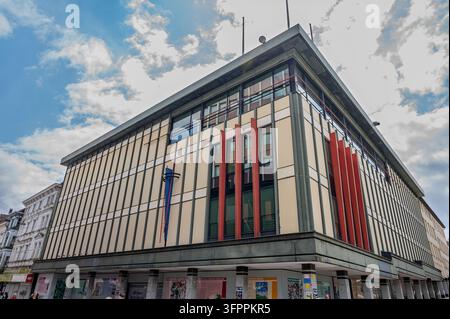 Lüdenscheid, Deutschland - 23. Juli 2026: Fassade eines Gewerbegebäudes mit markanten vertikalen Architekturpaneelen und Fenstern in der Innenstadt von Lüdenscheid. Stockfoto