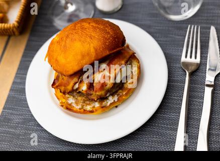 Leckerer Hamburger mit Schnitzel, Käse und Speck aus nächster Nähe Stockfoto