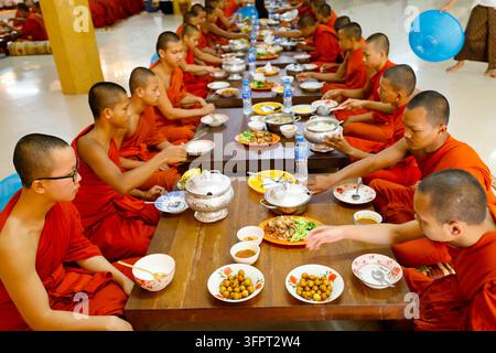 Wat Bo Tempel. Buddhistische Mönche in orangefarbenen Roben teilen eine Gemeinschaftsmahlzeit. Siem Reap. Kambodscha. Stockfoto