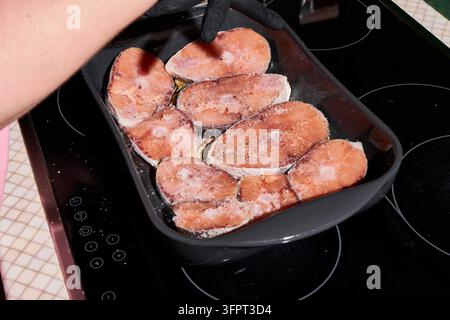 Rohe Lachssteaks in einer Backform mit Gewürzen auf dem Herd angerichtet, mit Lachs, Steak, Fisch, Filet-Detail, zeigt rohes, rosa, orange Fleisch Stockfoto