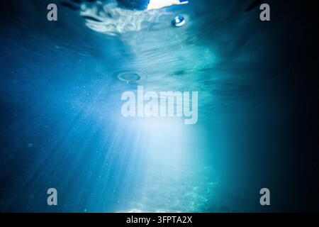 Ansicht von Lichtstrahlen, die die klare blaue Wasseroberfläche im Vereinigten Königreich durchdringen. Stockfoto