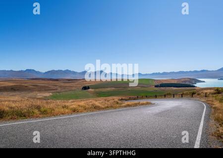 Straßenhintergrund, Automobil-Rückplatte, gepflasterte Haarnadelkurve in einer begehrten ländlichen Landschaft mit weitläufigen Aussichten Stockfoto
