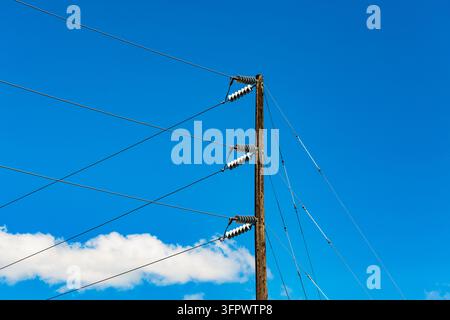 Telekommunikationsmast und Drähte, Kommunikationsleitungen vor einem blauen Himmel. Stockfoto