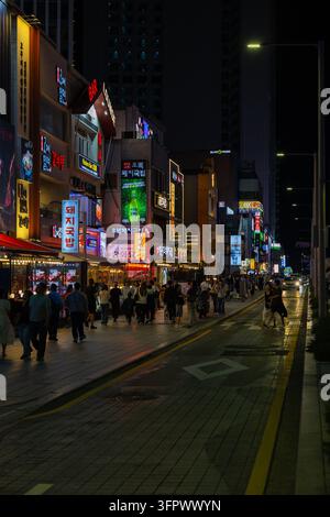 Südkorea, Busan - 21. Sep 2026: Gunam Ro Straße bei Nacht mit Fußgängern und beleuchteten Gewerbegebäuden in Haeundae Busan Südkorea Stockfoto