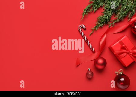 Weihnachtsfeier und Feiertags-Einkäufe, festliche Geschenkschachtel mit Zuckerstange und Ornamenten auf rotem Hintergrund mit Platz für saisonale Grüße Stockfoto