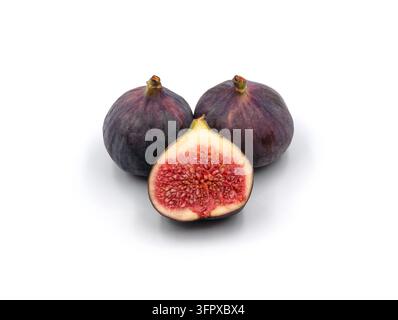 Zwei reife violette Feigen, von denen eine aufgeschnitten ist, um das saftige rote Fruchtfleisch und die Samen zu zeigen, isoliert auf weißem Hintergrund Stockfoto