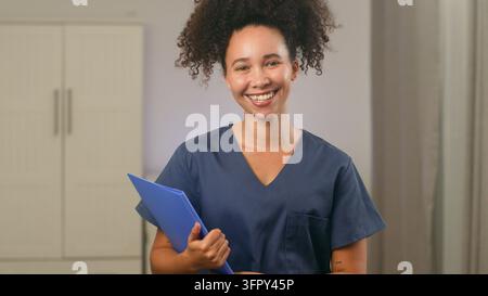 Krankenschwester hält eine Patientenakte, während sie in einer Klinik steht Stockfoto