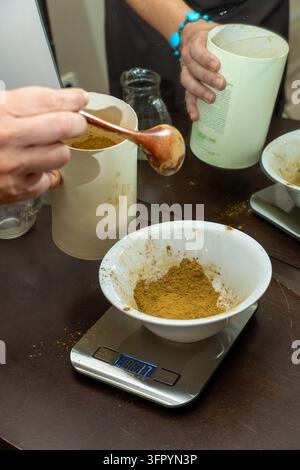 Abwägen von organischem Kräuterpulver für natürliche Haarfärbemittel Stockfoto