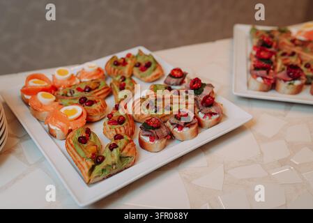 Verschiedene Gourmet-Canapee-Vorspeisen mit geräuchertem Lachs und Avocado Stockfoto