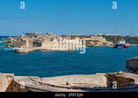 Historische Steinfortifikation und Leuchtturm mit Blick auf das blaue Meer in Malta Stockfoto
