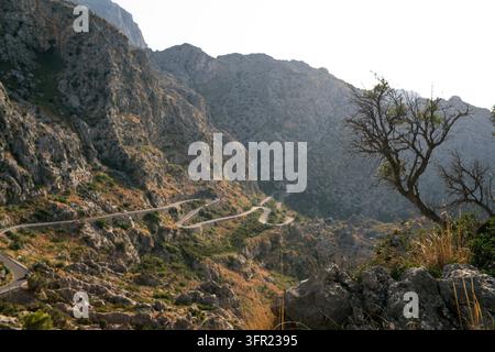 Eine Hochwinkelaufnahme zeigt eine gewundene, schlangenförmige Straße, die sich durch das raue, felsige Gelände der Serra de Tramuntana-Berge auf Mallorca, Spai windet Stockfoto