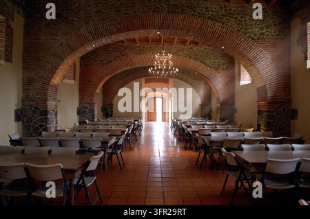 Innenhalle mit freigelegten roten Ziegelbögen und traditioneller rustikaler Architektur in einer historischen Hazienda in Puebla. Helles Naturlicht streut Stockfoto