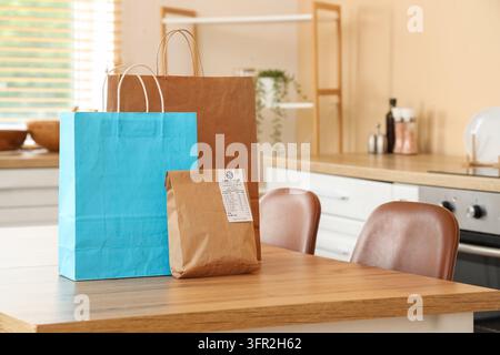 Einkaufen und Inflation, Papiertüten mit Lebensmittellieferung auf dem Küchentisch steigende Lebenshaltungskosten und Haushaltsbudgetverwaltung Stockfoto