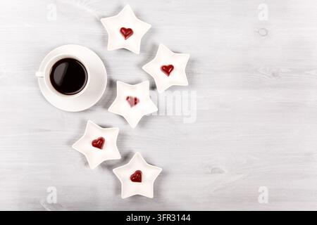 Tasse Kaffee und Sterngerichte mit Herzensbonbons Stockfoto