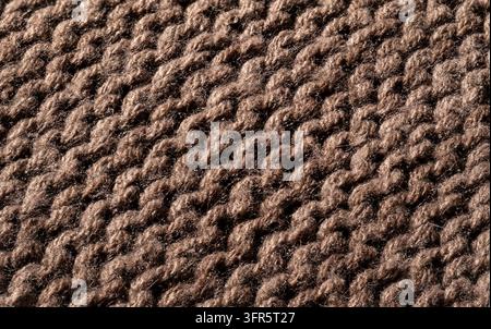 Brauner Wollstoff mit einer detaillierten Makrotextur des Strickens, der ein gemütliches und warmes Hintergrundmaterial bietet Stockfoto