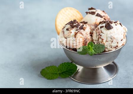 Hausgemachtes Schokoladen- und Vanilleeis mit Schokoladenstückchen und Keksen in einer Metallschüssel. Sommerdessert Stockfoto