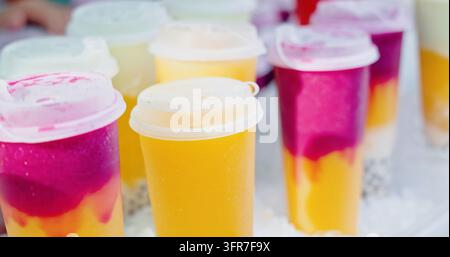 Frucht-Bubble-Tea-Tassen stehen auf einem Eisbett, Imbissstand auf einem Straßennahrungsmarkt im Freien, erfrischende Sommergetränke mit Tapioka-Perlen, kommerzielles Getränkephoto Stockfoto