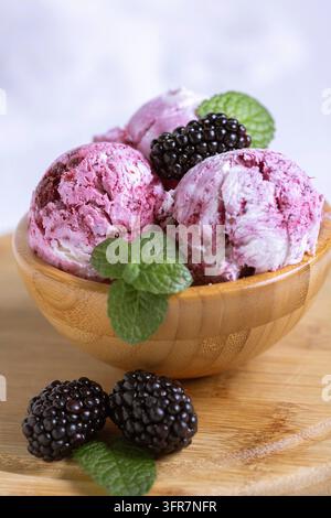 Hausgemachtes Brombeer-Eis in einer Holzschale mit Beeren und Minzgezweig. Sommerdessert Stockfoto