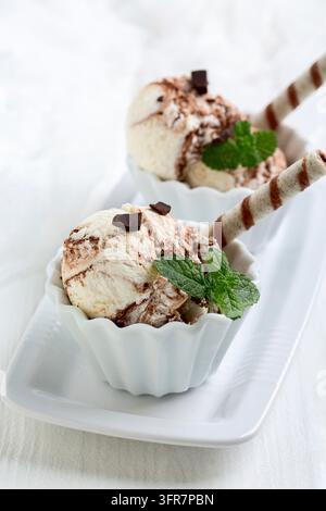 Cremiges Vanilleeis mit Schokoladen- und Minz-Garnitur Stockfoto