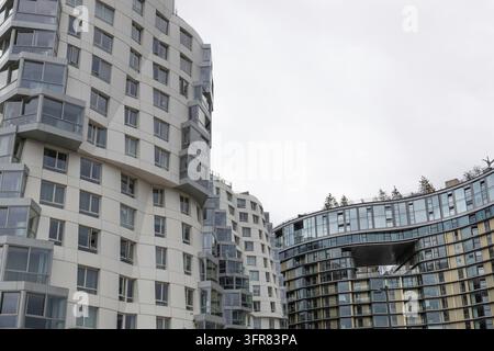 Zeitgenössischer Wohnkomplex mit einzigartigem geschwungenem architektonischem Design und zahlreichen Fenstern an einem bewölkten Tag Stockfoto