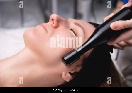 Hardware-Facelift-Verfahren. Hardware-Kosmetik. Eine schöne Frau, die eine Lymphdrainage-Behandlung im Büro eines Kosmetikers erhält Stockfoto