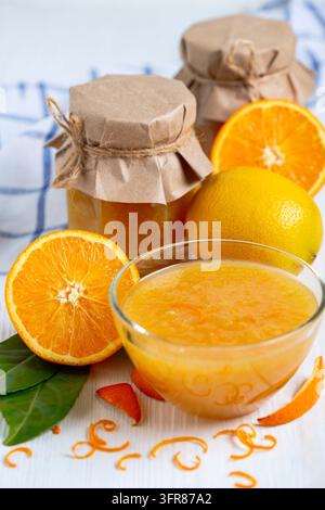 Hausgemachte Orangen- und Zitronenmarmelade in Gläsern und einer Glasschale, Nahaufnahme, selektiver Fokus Stockfoto
