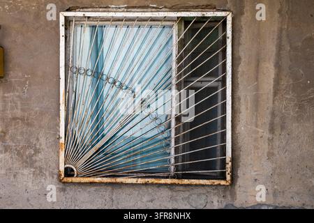 Dekorative rostige Metallfensterläden mit einem Sonnenstrahlenmuster, montiert an einer Betonwand, Jerewan, Jerewan, Armenien Stockfoto