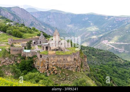Das Tatev-Kloster und seine Steinmauern mit Blick auf eine tiefe bewaldete Schlucht in den Bergen, Provinz Syunik, Tatev, Armenien Stockfoto