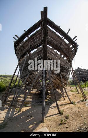 Der hölzerne Bug eines großen Dhow steht auf Holzstützen in einer Freiluft-Werft, Gujarat, Mandvi, Indien Stockfoto